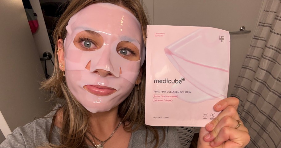 woman wearing a pink medicube mask and holding a box