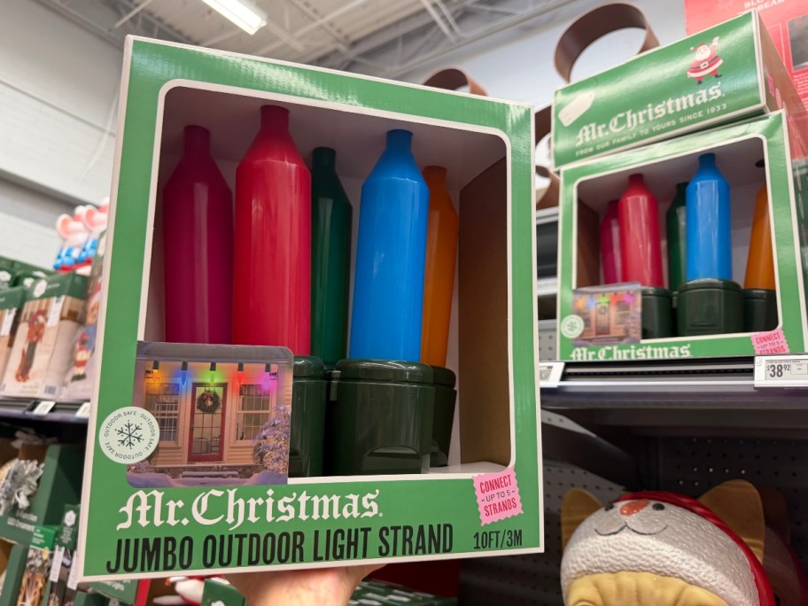holding a box of jumbo Christmas lights