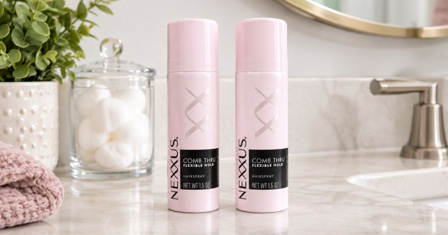 two small cans of Nexxus hair spray on a bathroom counter