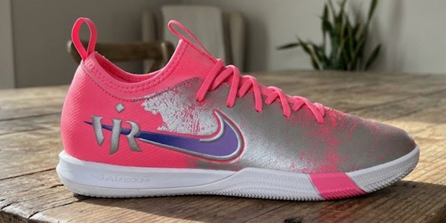 pink, purple and gray nike shoe laying on table