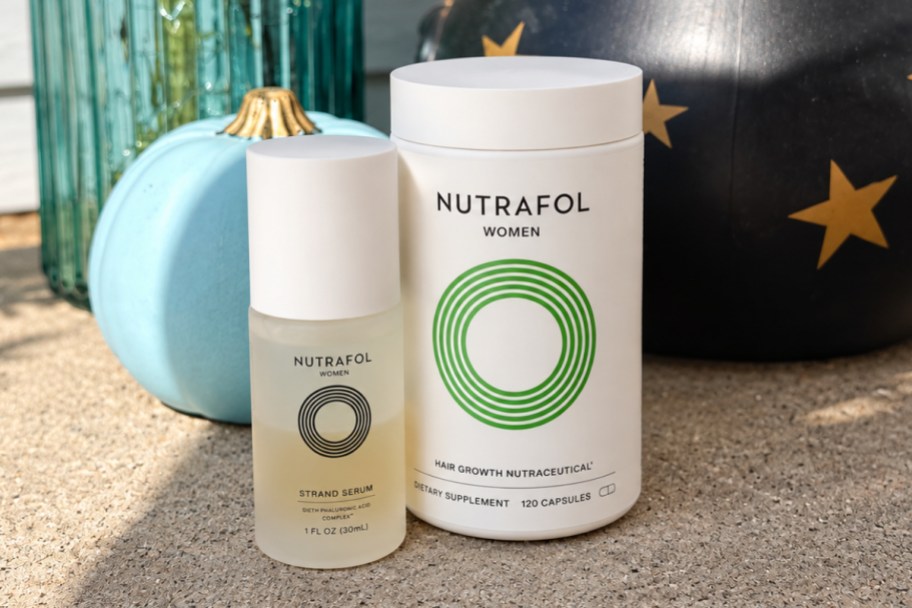a bottle of strand serum with a bottle of women's Nutrafol