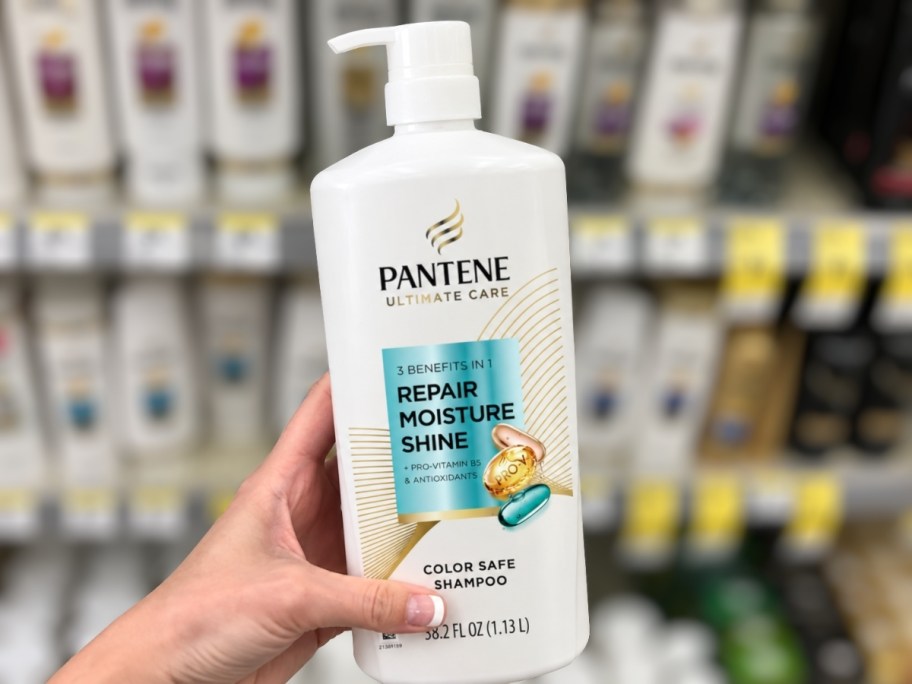 hand holding a large bottle of shampoo