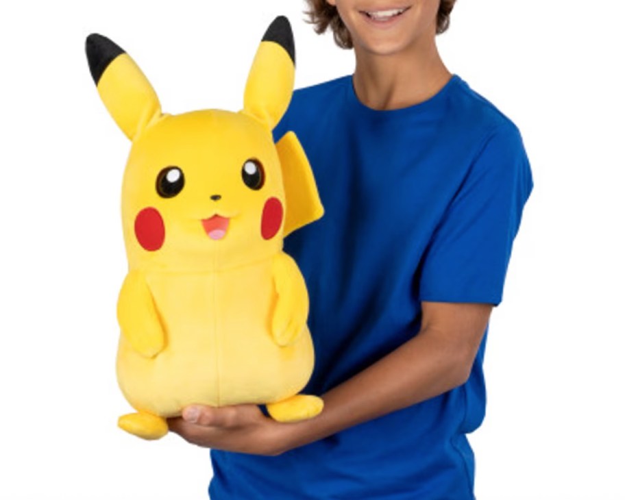 boy holding giant pikachu puppet