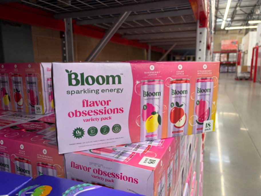 Stacked 18-pack cases of Bloom Sparkling Energy Flavor Obsessions variety pack cans displayed on a warehouse store shelf.