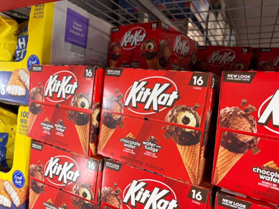 Stacked 16-count boxes of Kit Kat chocolate wafer frozen dessert cones displayed on a freezer shelf.
