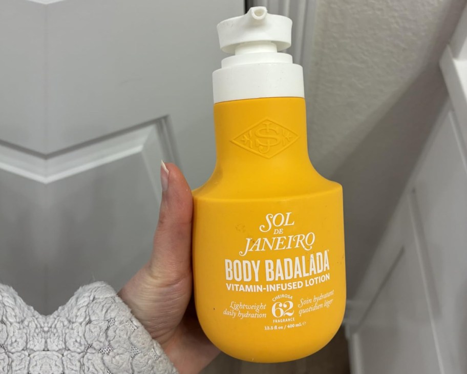 hand holding yellow lotion bottle