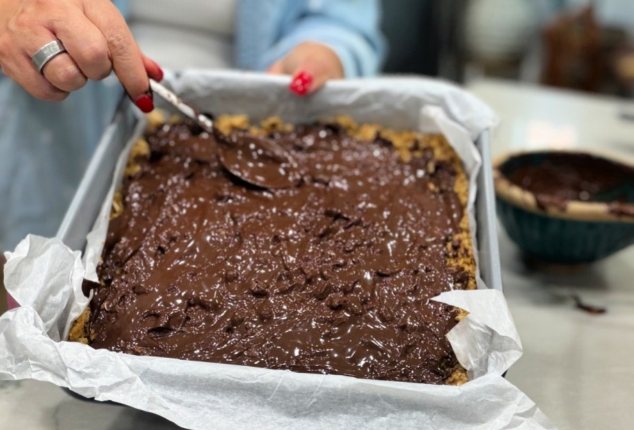 spreading chocolate on top of bars