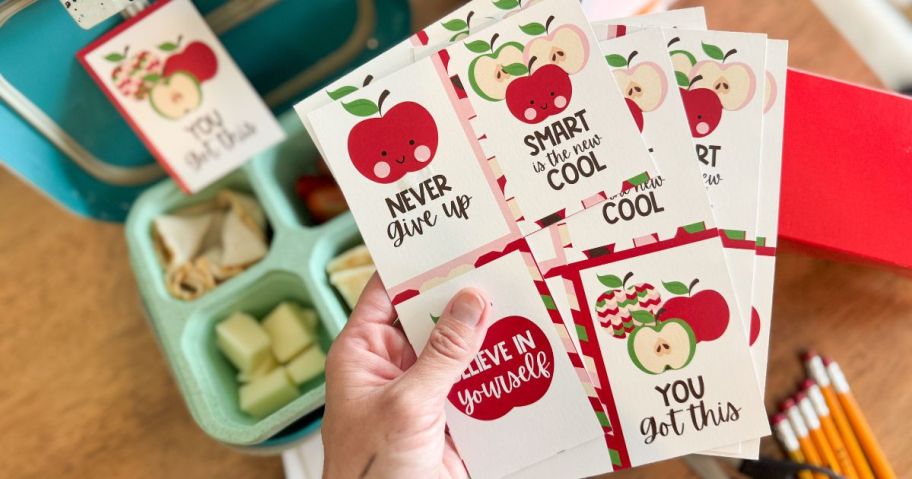 hand holding 5x7 Premium Photo Card 6-Pack above kids' lunch box