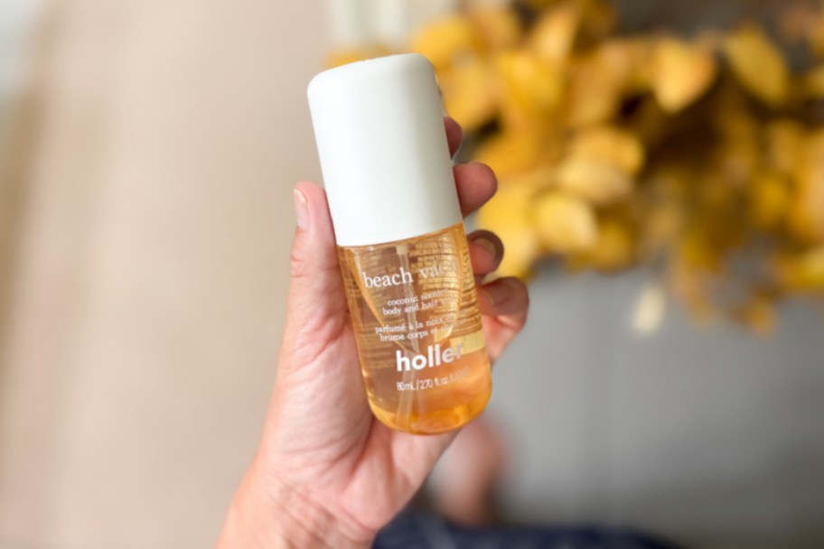 hand holding gold spray with white lid