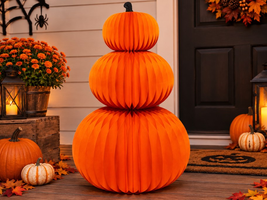 three orange stacked pumpkin paper honeycomb decor on porch 