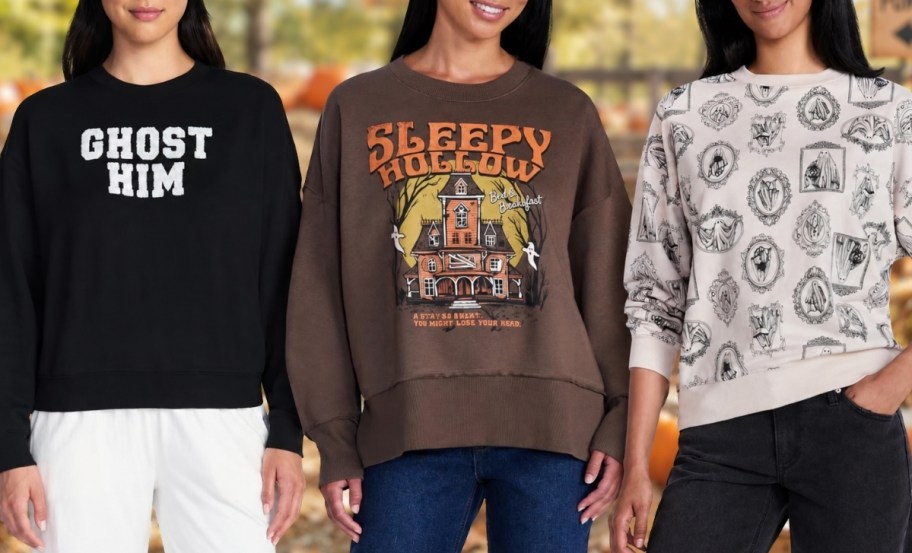 three women wearing halloween graphic sweatshirts
