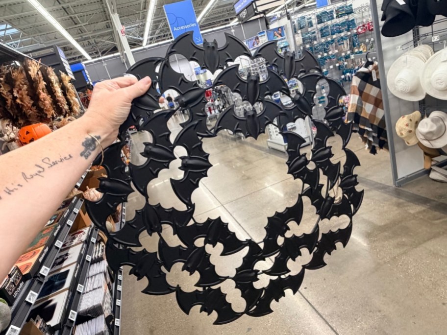 womans hand hlding a bat wreath
