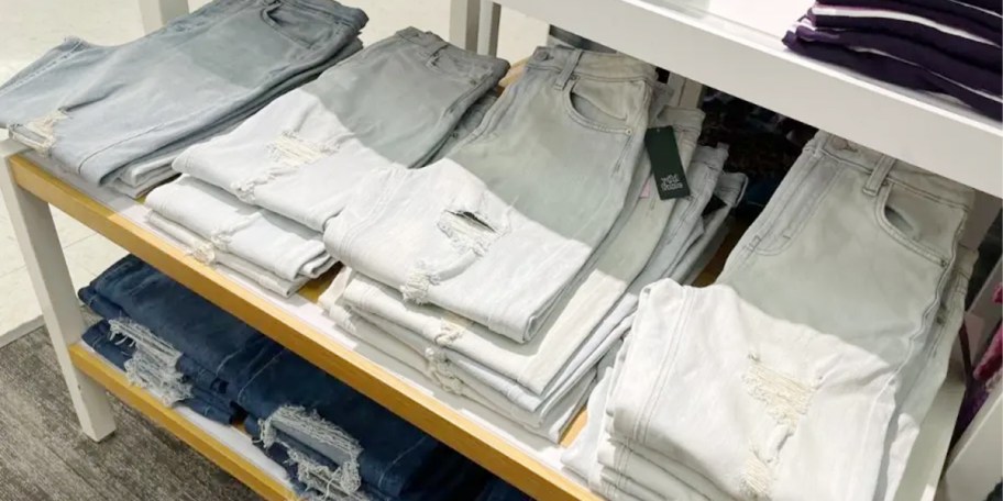 light blue jeans folded on display in store 