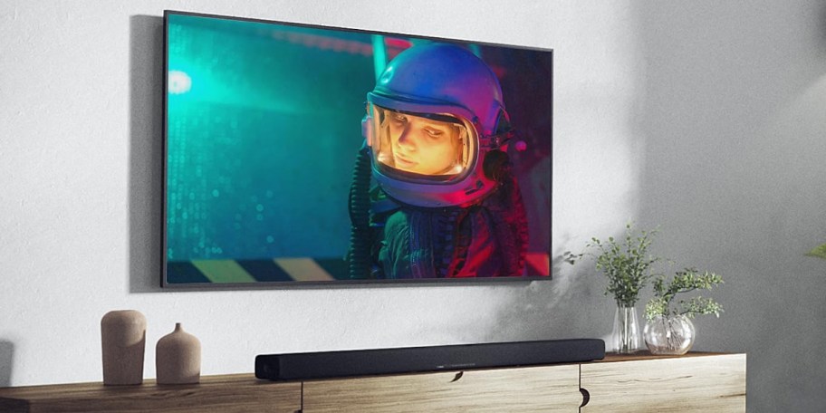 tv hanging on wall with soundbar below it 