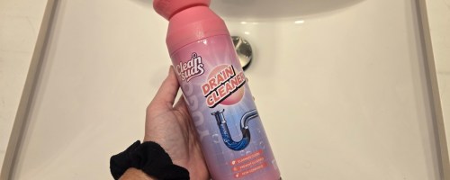 womans hand holding a can of foaming drain cleaner