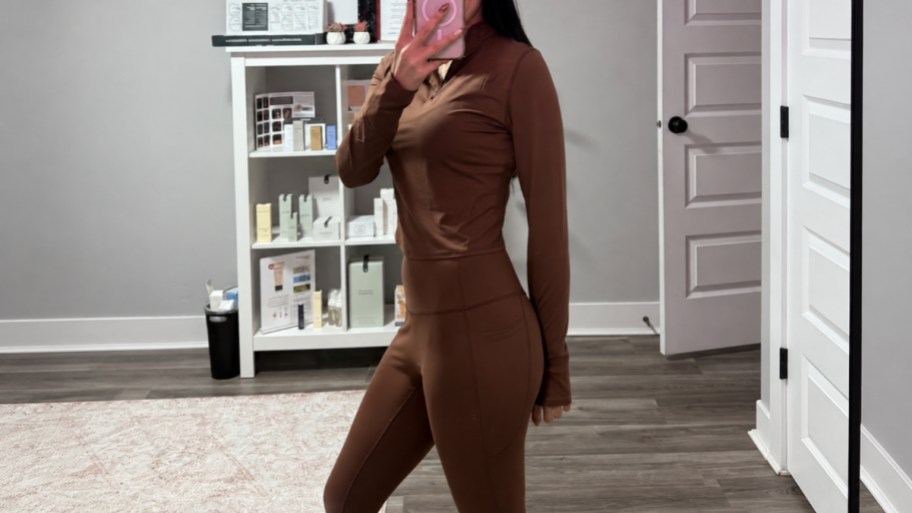 womena taking a selfie wearing a brown 2 piece workout outfit