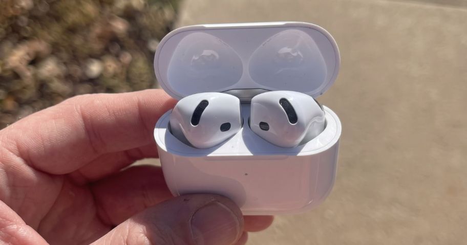 hand holding Apple AirPods 4 outside