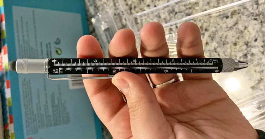 hand holding a black multitool pen