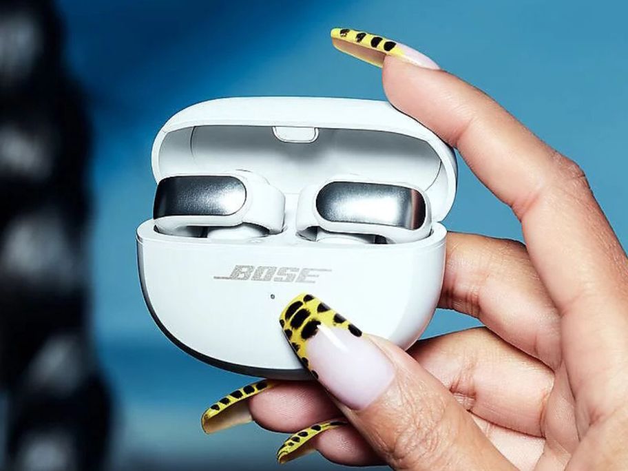 hand holding white Bose Ultra Open Earbuds