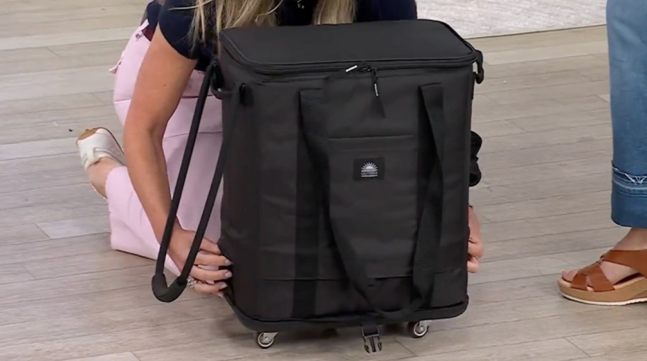 A California Innovations insulated mega roller bag with a detachable base and carrying handles, shown on a wooden floor.