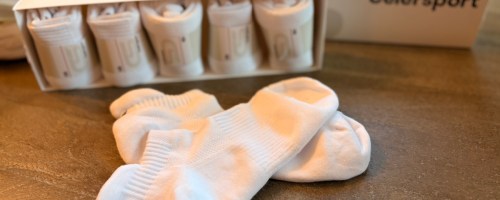 Six pack of white ankle socks displayed on kitchen table