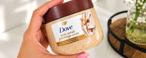 Hand-holding dove body scrub in bathroom