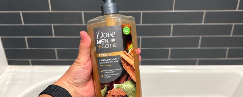 hand holding Dove Men Care Sandalwood Body Wash inside shower