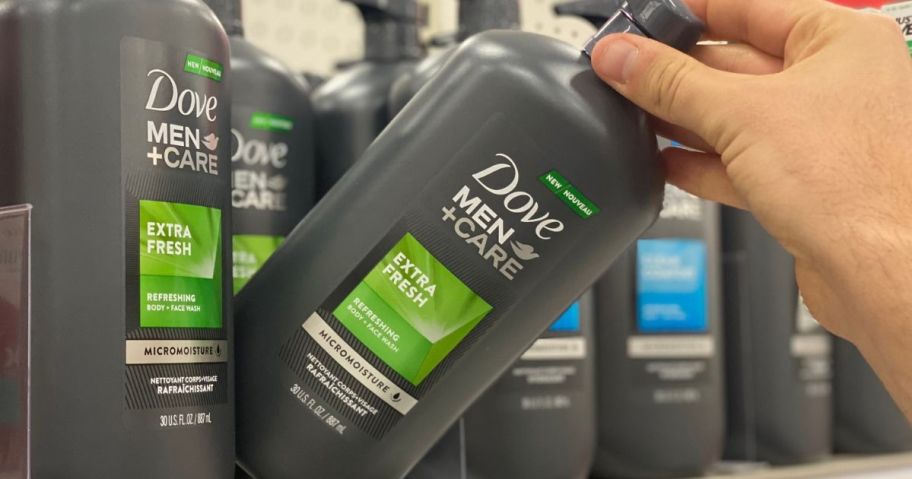 Hand grabbing a large bottle of Dove Men's Body Care from a store shelf