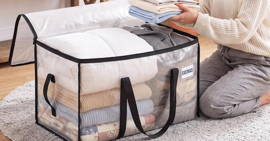 woman placing folded towels into storage bag
