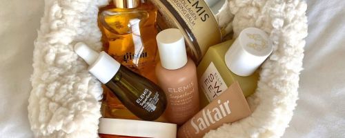 A sherpa pouch filled with Elemis Skincare and other beauty products
