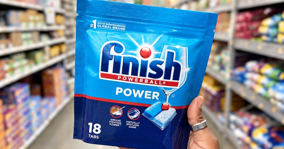 hand holding up a blue pack of Finish Power Dishwasher Pods in store aisle