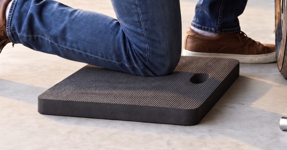 Man's knee on a black foam pad