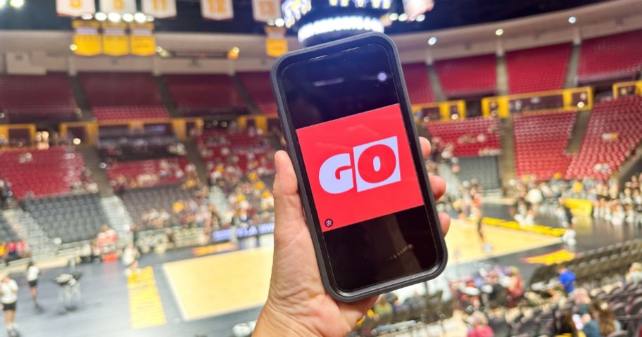 person holding phone with get out pass logo displayed on screen