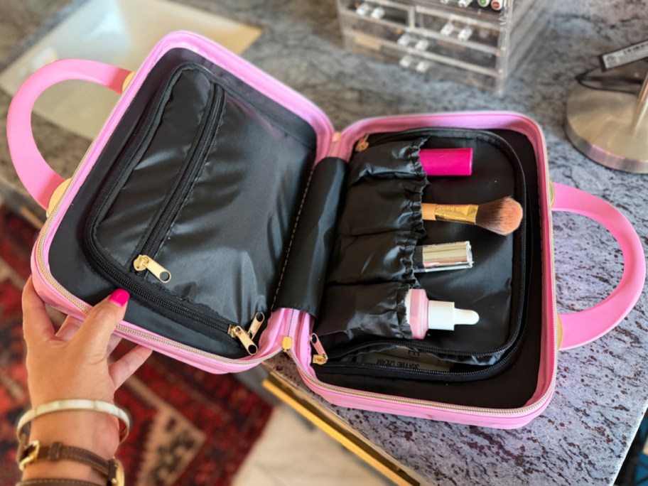 hand opening a pink cosmetics case