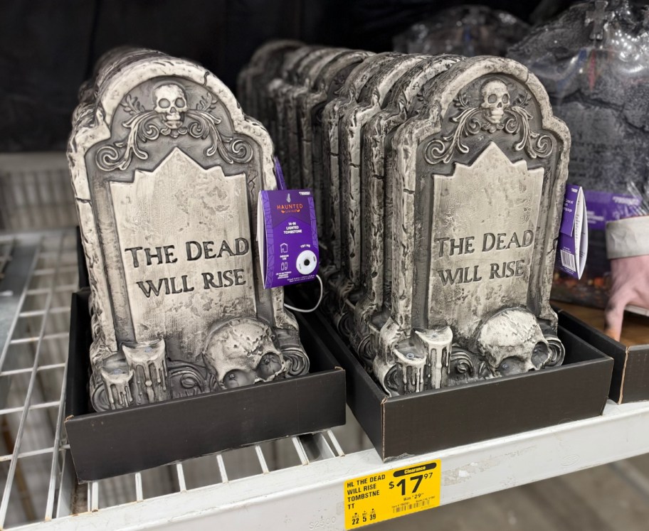 two lighted tombstone decor on stor shelf