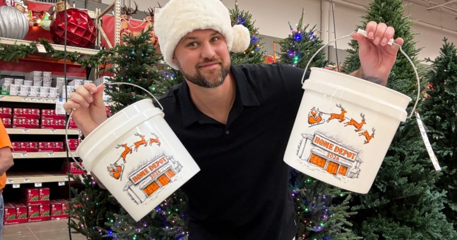 man holding up 2 Home Depot Christmas buckets