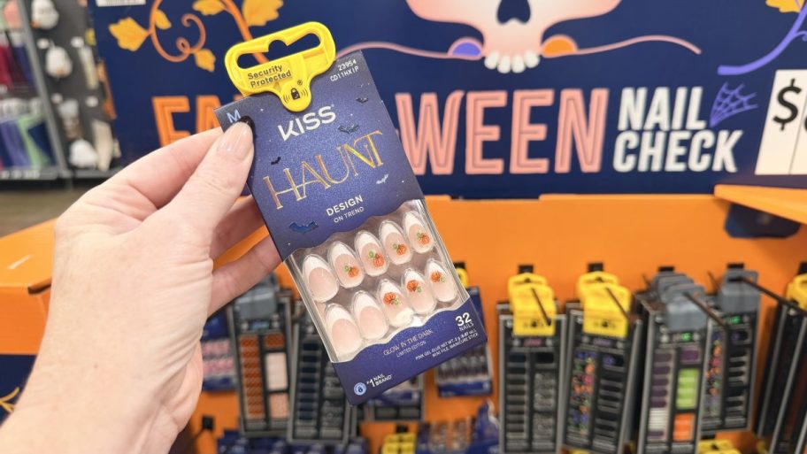 package of halloween press on nails held in hand in front of store display