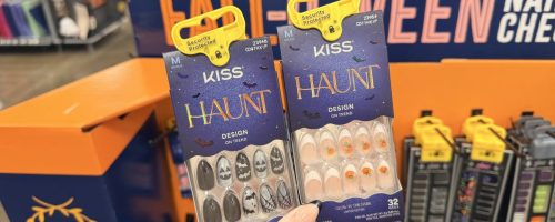 two packages of press on nails held in front of a store display