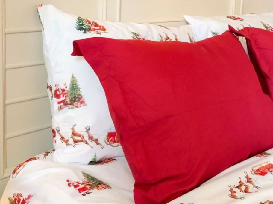 Linens & Hutch Holiday Sheets with Santa on a bed with red shams