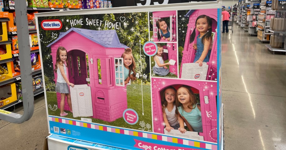 A large retail box for a pink Little Tikes Cape Cottage playhouse displayed inside a store.