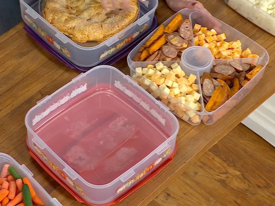 LocknLock Harvest printed appetizer and dessert tray containers filled with cubed cheese, sliced sausage, and baked snacks on a wooden table.