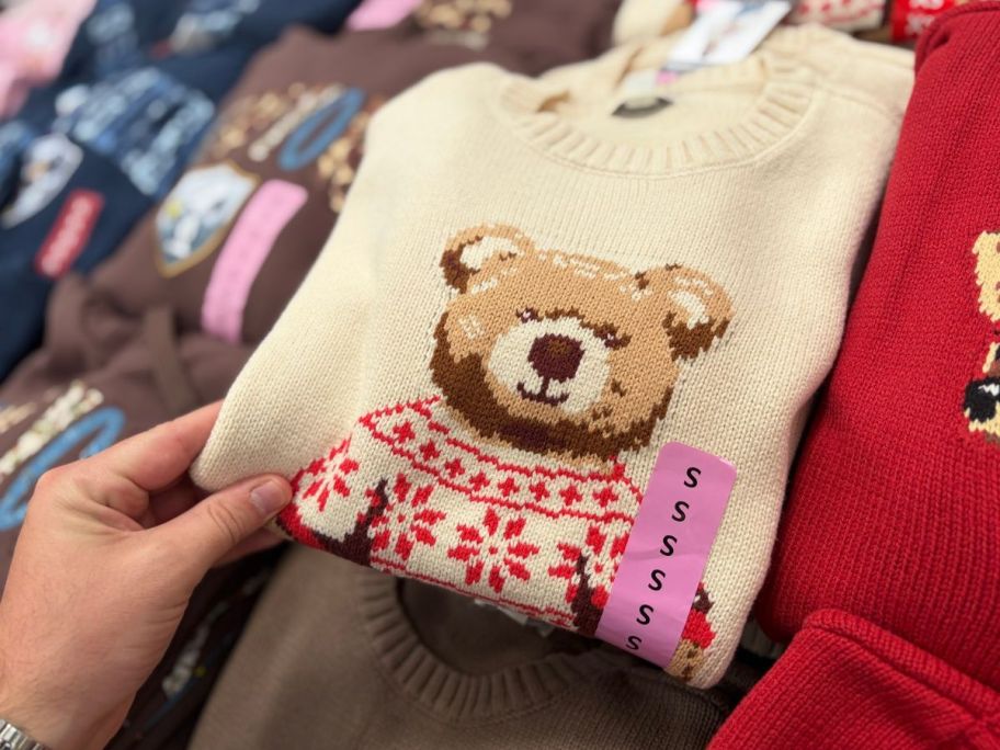 hand holding Mighty Fine Women's Icon Sweater in store