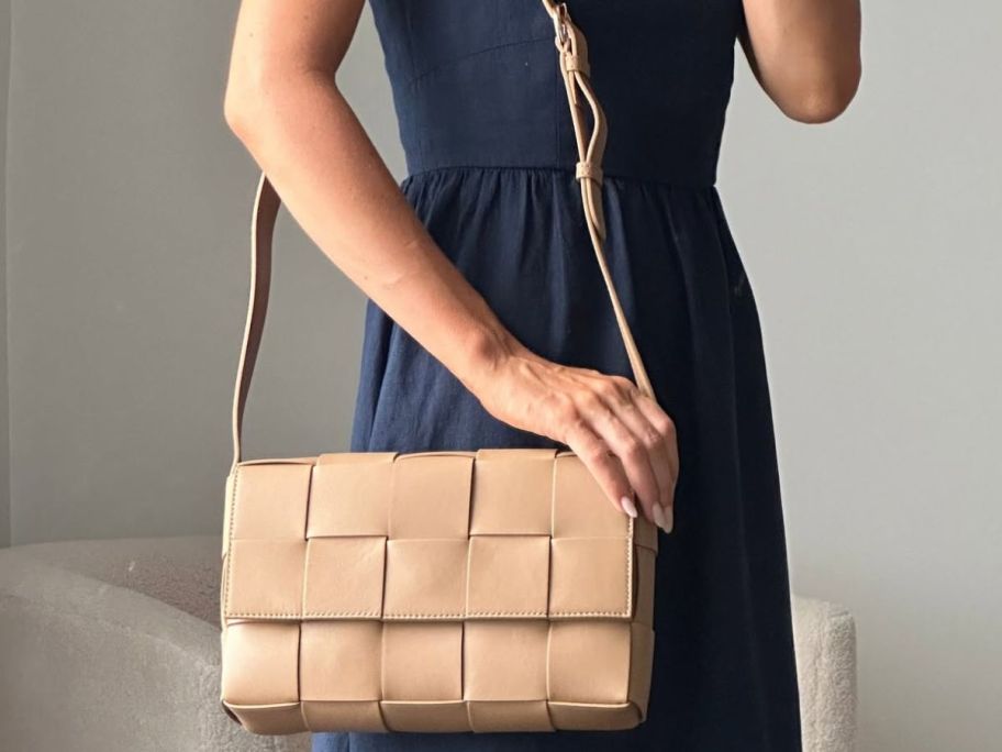 Woman wearing a Quince Woven Flap Crossbody bag