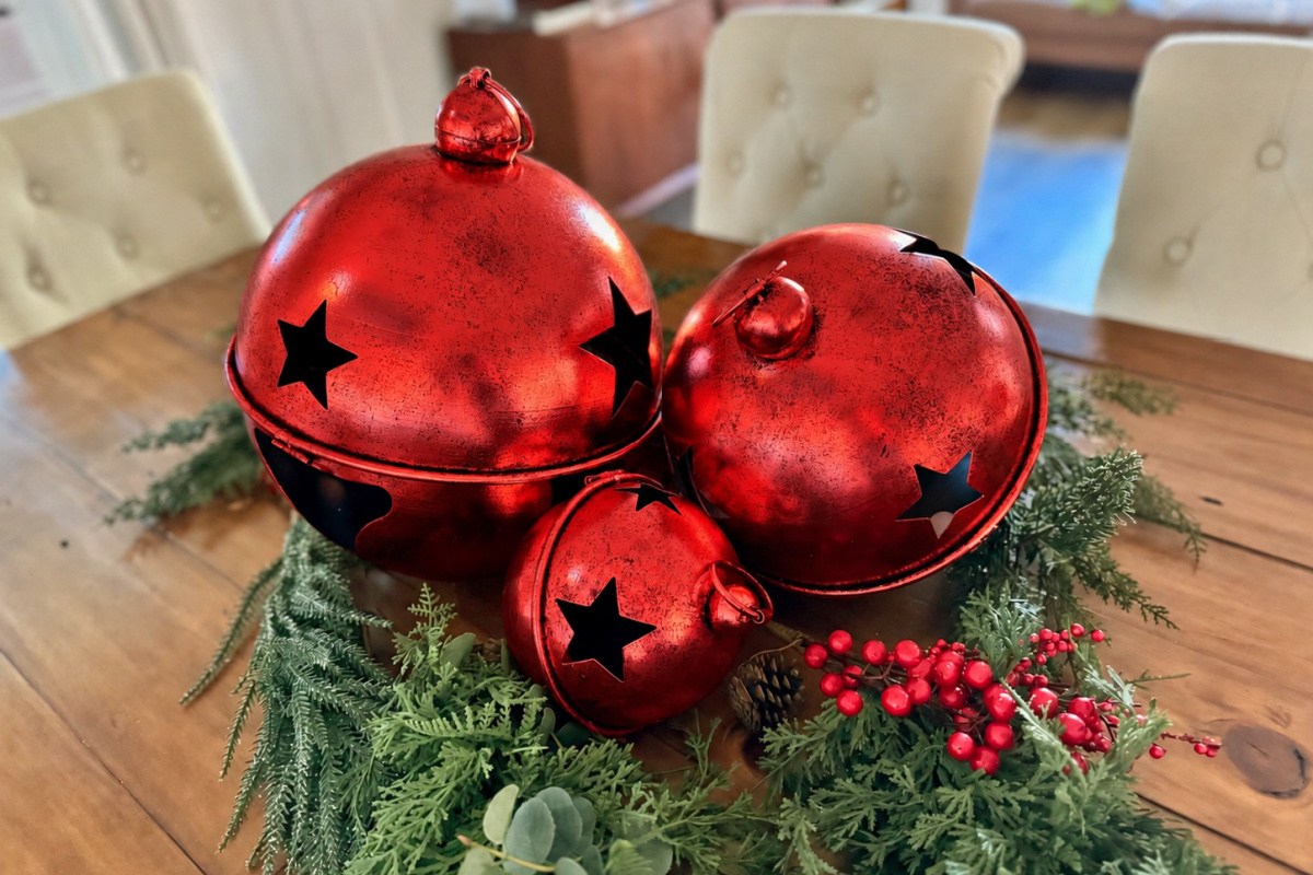 Red antique holiday jingle bells on dining room table in centerpiece