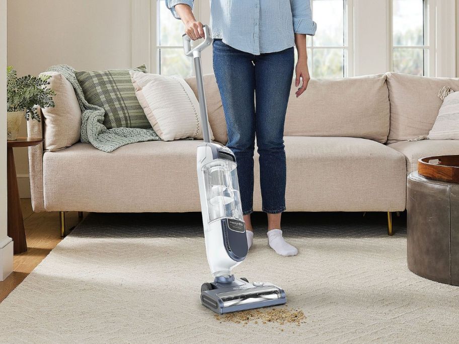 person using Shark FreeStyle Max Cordless Upright Vacuum in living room