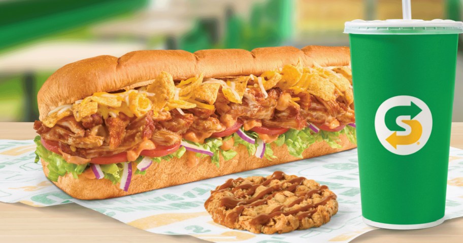 Subway Frito footlong sandwich and apple cookie and drink on restaurant tabletop