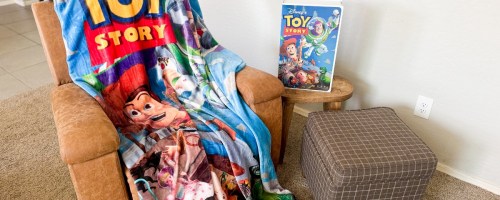 disney vhs box and blanket with toy story draped over chair in living room