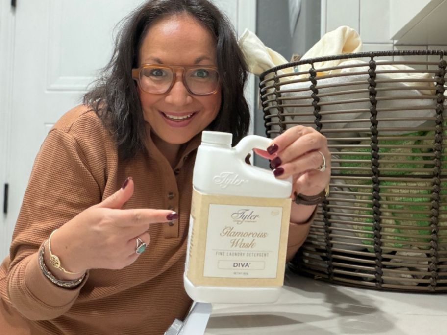 Lina holding Tyler Candle Company’s Glamorous Wash bottle in laundry room