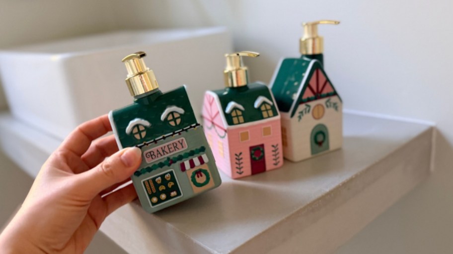womans hand holding a bottle of christmas village hand soaps