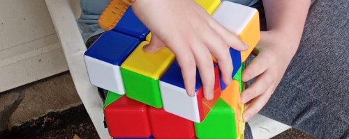 person solving a giant puzzle cube